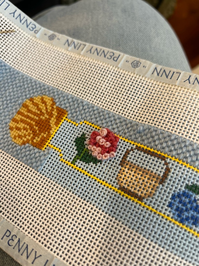 French-knot flower, shell, and basket on a needlepoint belt